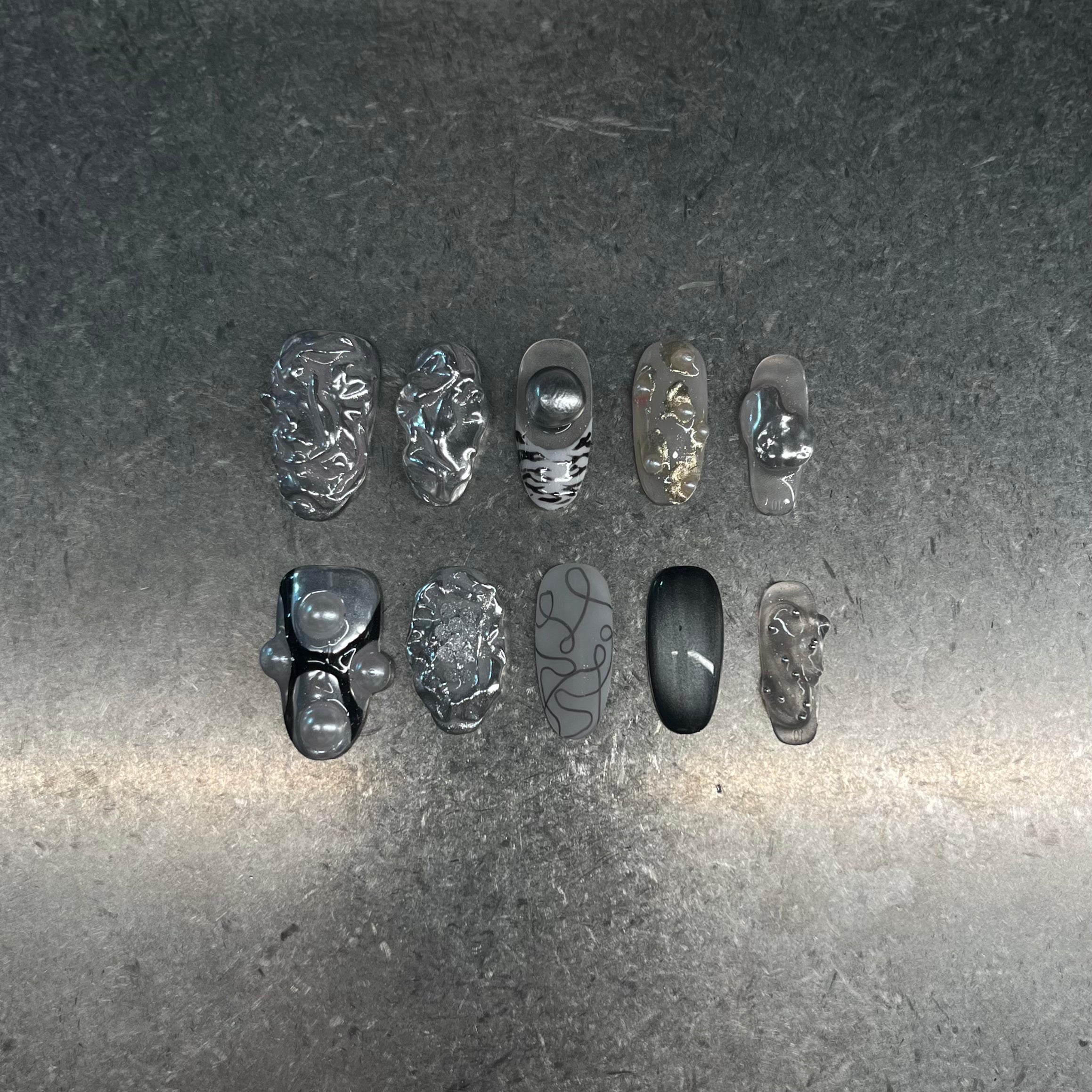 Handmade silver 3D almond press-on nails from Fjaka Nails, featuring raised silver texture, pearls, steel beads, clear base, zebra print, cat eye and abstract designs, salon-quality reusable nails for UK niche industrial aesthetic lovers.